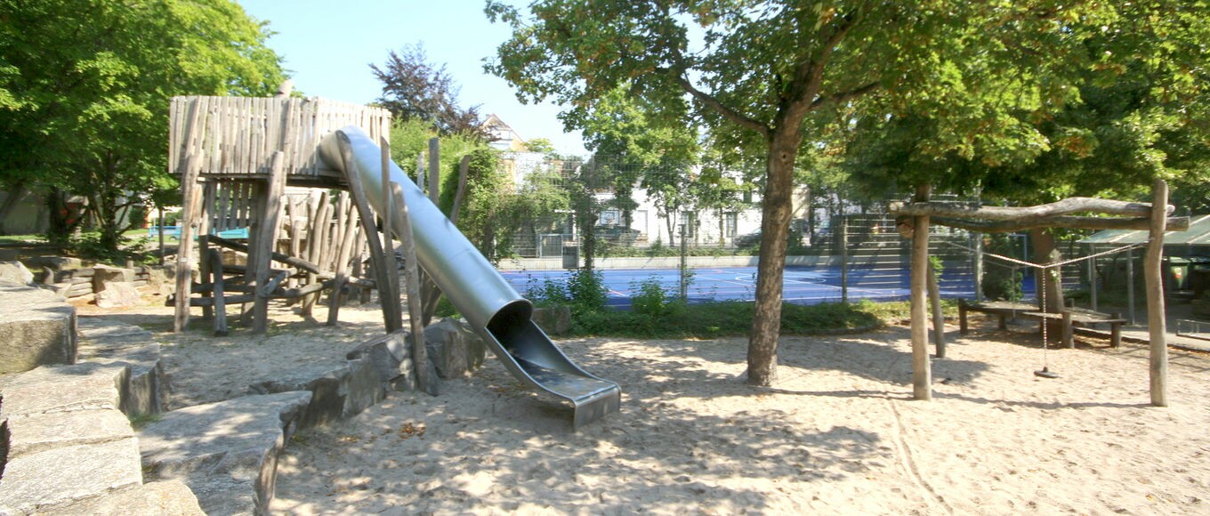 Begrünter Spielplatz mit einer Rutsche